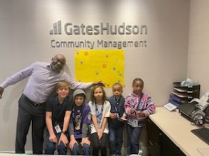 GHCM employee posing with children in front of company logo